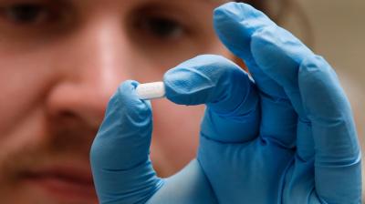 A pharmacy tech holds a pill of Hydroxychloroquine at Rock Canyon Pharmacy in Provo, Utah. (AFP)
