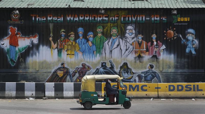 An auto rickshaw drives past a mural depicting frontline workers fighting against COVID-19 in New Delhi. AP Photo An auto rickshaw drives past a mural depicting frontline workers fighting against COVID-19 in New Delhi. AP Photo