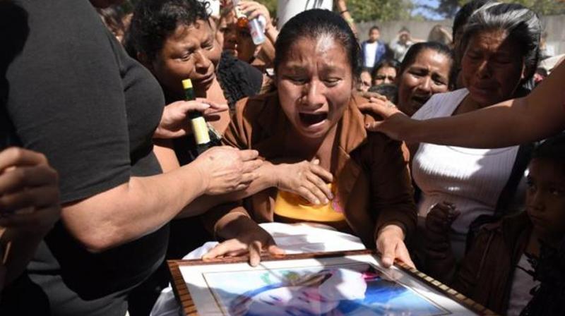 Marta Lidia Garcia cries over the coffin of her 17-year-old daughter Siona Hernandez, who died in a fire at a state-run shelter, during her funeral at the general cemetery in Guatemala City. (Photo: AFP