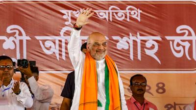 Union Home Minister Amit Shah acknowledges supporters during a public rally in support of BJP candidates Sukanta Majumdar and Khagen Murmu for the upcoming Lok Sabha election, near Daulatpur in South Dinajpur district, Wednesday, April 10, 2024. (PTI Photo)