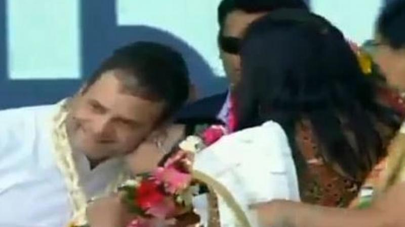 Rahul Gandhi blushed after the woman drags down his head and kisses him. (Photo: ANI | Twitter)