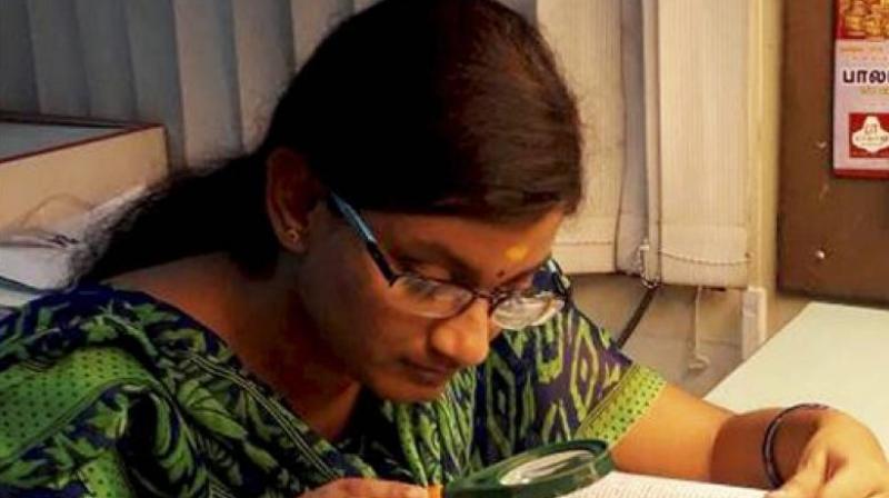 Hailing from Krishnagiri in Tamil Nadu, Dharshana, who has almost nil vision in right eye and partial in left, uses magnifying glass to read. (Photo: File) Hailing from Krishnagiri in Tamil Nadu, Dharshana, who has almost nil vision in right eye and partial in left, uses magnifying glass to read. (Photo: File)