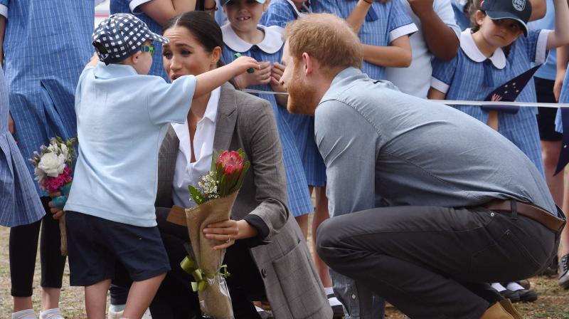 Britain's Prince Harry (R) looks on as his wife Meghan, the Duchess of Sussex is hugged by student Luke Vincent of Buninyong Public School following the couple's arrival at Dubbo Regional Airport in Dubbo on October 17, 2018. (Photo: AFP) Britain's Prince Harry (R) looks on as his wife Meghan, the Duchess of Sussex is hugged by student Luke Vincent of Buninyong Public School following the couple's arrival at Dubbo Regional Airport in Dubbo on October 17, 2018. (Photo: AFP)