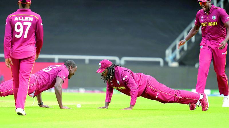West Indies captain Jason Holder (left) and teammate Chris Gayle do push ups to celebrate the wicket of Afghanistan’s Rahmat Shah during their group stage match at Headingley in Leeds on Thursday. (Photo: AFP) West Indies captain Jason Holder (left) and teammate Chris Gayle do push ups to celebrate the wicket of Afghanistan’s Rahmat Shah during their group stage match at Headingley in Leeds on Thursday. (Photo: AFP)