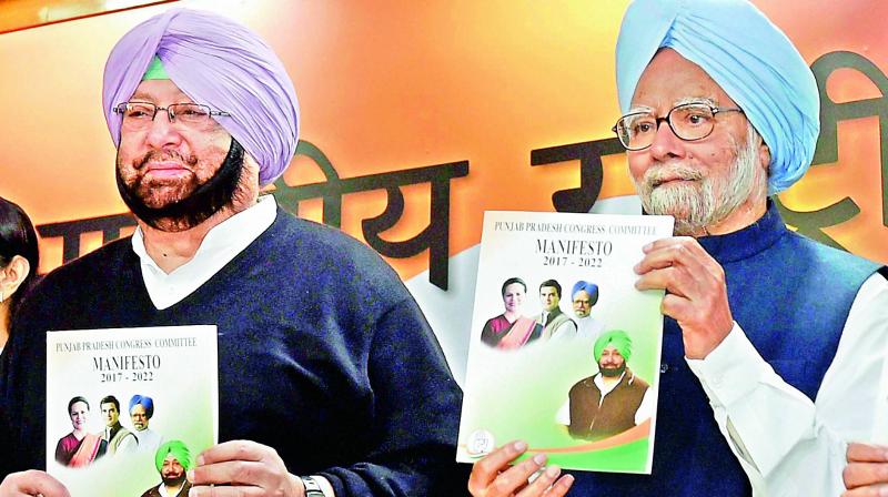 Former Prime Minister Manmohan Singh with Punjab Congress president Capt. Amarinder Singh releases the Congress manifesto in New Delhi on Monday. (Photo: PTI) Former Prime Minister Manmohan Singh with Punjab Congress president Capt. Amarinder Singh releases the Congress manifesto in New Delhi on Monday. (Photo: PTI)