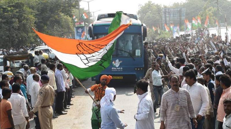 A Congress supporter waves party flag at Prantij town, some 65 kms from Ahmedabad on November 11, 2017. (Photo: AFP) A Congress supporter waves party flag at Prantij town, some 65 kms from Ahmedabad on November 11, 2017. (Photo: AFP)