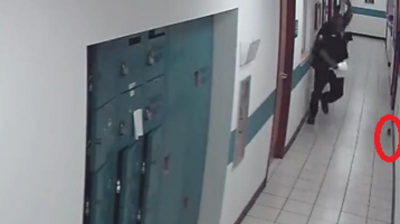 The video posted on Youtube is a CCTV footage grab of the St Petersburg Police Department in Florida where the police officer is busy getting his work done. (Photo: Youtube) The video posted on Youtube is a CCTV footage grab of the St Petersburg Police Department in Florida where the police officer is busy getting his work done. (Photo: Youtube)