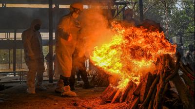  Volunteers in personal protective equipment (PPE) suits and relative perform the last rites during the cremation of a person who died due to the Covid-19 coronavirus, at a cremation ground in New Delhi. (Photo: AFP)