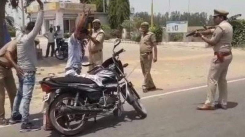 A video and some photographs of the policemen frisking people and checking their vehicles with one policeman pointing a gun at them, forcing them to stand motionless in hands-up position has gone viral on various social media platforms. (Photo: ANI) A video and some photographs of the policemen frisking people and checking their vehicles with one policeman pointing a gun at them, forcing them to stand motionless in hands-up position has gone viral on various social media platforms. (Photo: ANI)