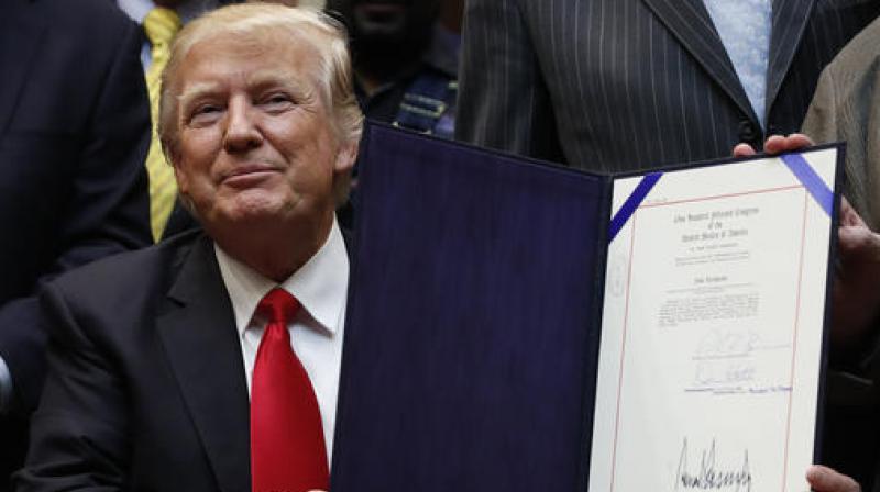 US President Donald Trump holds up H.J. Res. 38 after signing it in the Roosevelt Room of the White House. (Photo: AP) US President Donald Trump holds up H.J. Res. 38 after signing it in the Roosevelt Room of the White House. (Photo: AP)