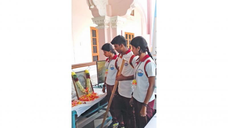 Students pay homage to Mahatma Gandhi after the rally reached Tiruchy on Tuesday. The lathi carried in the rally is also seen. (Photo: DC) Students pay homage to Mahatma Gandhi after the rally reached Tiruchy on Tuesday. The lathi carried in the rally is also seen. (Photo: DC)