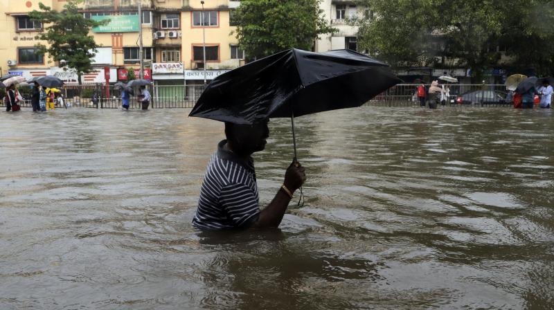 A man wades through a waterlogged street following heavy rains in Mumbai on Tuesday. (Photo: AP) A man wades through a waterlogged street following heavy rains in Mumbai on Tuesday. (Photo: AP)