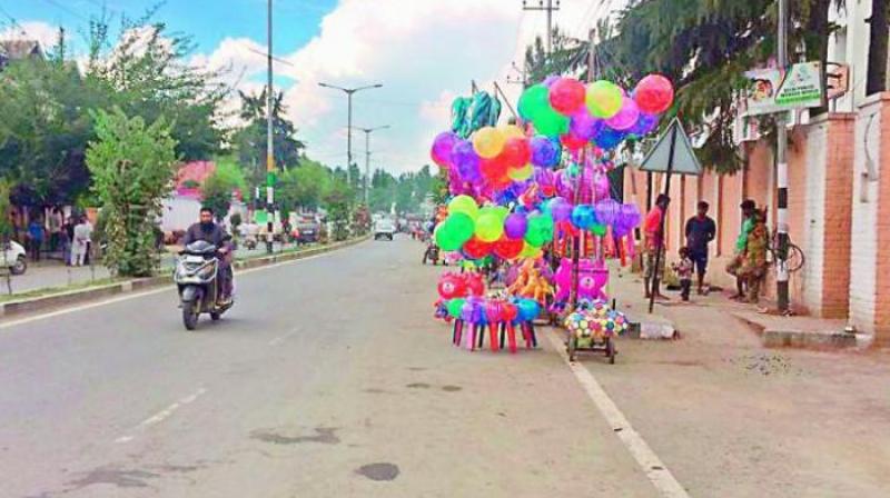 A vendor sells balloons at a street in Srinagar after curfew was relaxed ahead of Id on Sunday, but there appear to be few takers. (Photo: DC) A vendor sells balloons at a street in Srinagar after curfew was relaxed ahead of Id on Sunday, but there appear to be few takers. (Photo: DC)