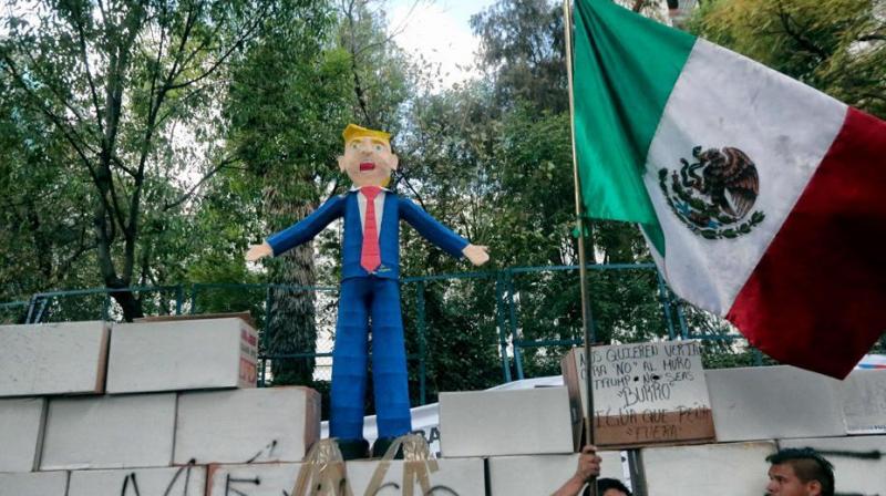 People protest against US President Donald Trump's inauguration next to a fake wall with a Mexican national flag and a dummy representing him in Mexico City.(Photo: AFP) People protest against US President Donald Trump's inauguration next to a fake wall with a Mexican national flag and a dummy representing him in Mexico City.(Photo: AFP)