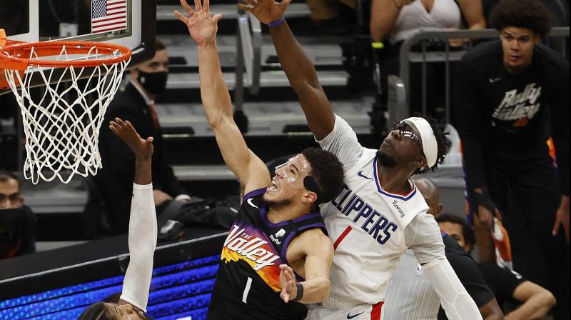 Devin Booker #1 of the Phoenix Suns goes up for a shot against Paul George #13 and Reggie Jackson #1 of the LA Clippers during the second half in Game 5 of the Western Conference Finals. (Photo: Getty images)