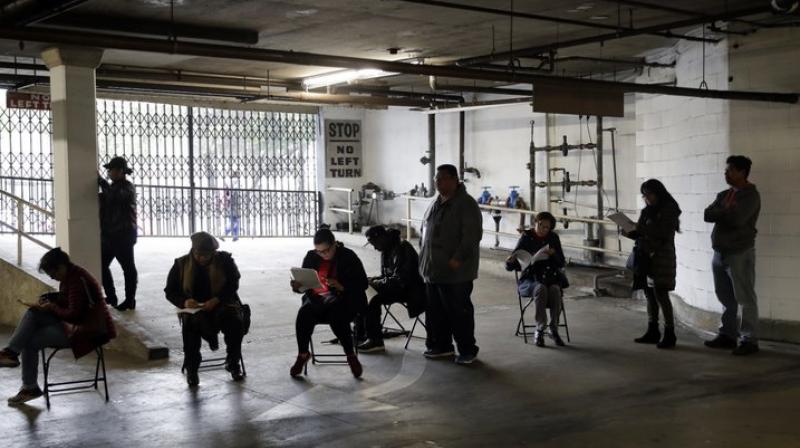 Unionized hospitality workers wait in line in a basement garage to apply for unemployment benefits at the Hospitality Training Academy in Los Angeles (Image- AP)) Unionized hospitality workers wait in line in a basement garage to apply for unemployment benefits at the Hospitality Training Academy in Los Angeles (Image- AP))