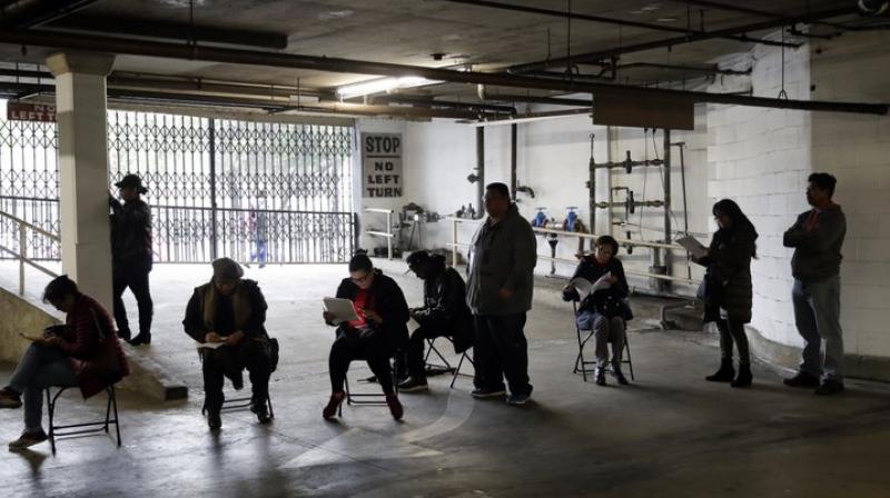 Unionized hospitality workers wait in line in a basement garage to apply for unemployment benefits at the Hospitality Training Academy in Los Angeles (Image- AP))