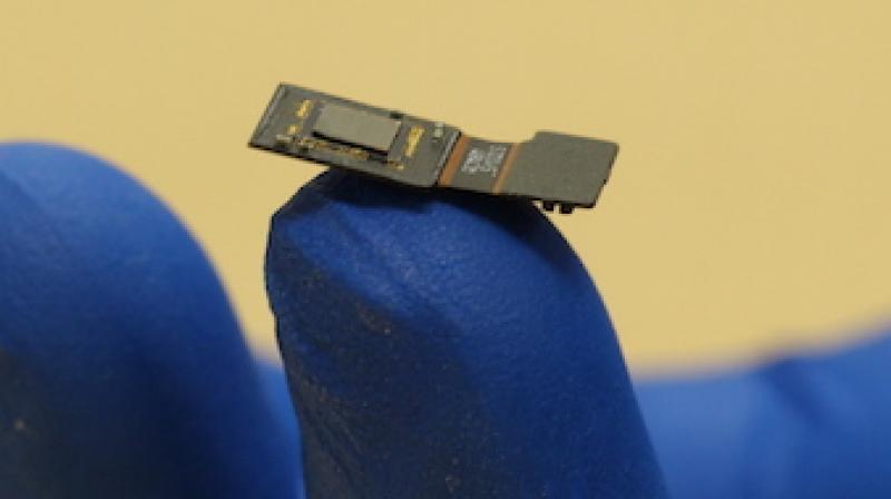 Rice engineers have built a lab prototype of a flat microscope they are developing as part of DARPA’s Neural Engineering System Design project. The microscope will sit on the surface of the brain, where it will detect optical signals from neurons in the cortex. The goal is to provide an alternate path for sight and sound to be delivered directly to the brain. (Image: Rice University) Rice engineers have built a lab prototype of a flat microscope they are developing as part of DARPA’s Neural Engineering System Design project. The microscope will sit on the surface of the brain, where it will detect optical signals from neurons in the cortex. The goal is to provide an alternate path for sight and sound to be delivered directly to the brain. (Image: Rice University)