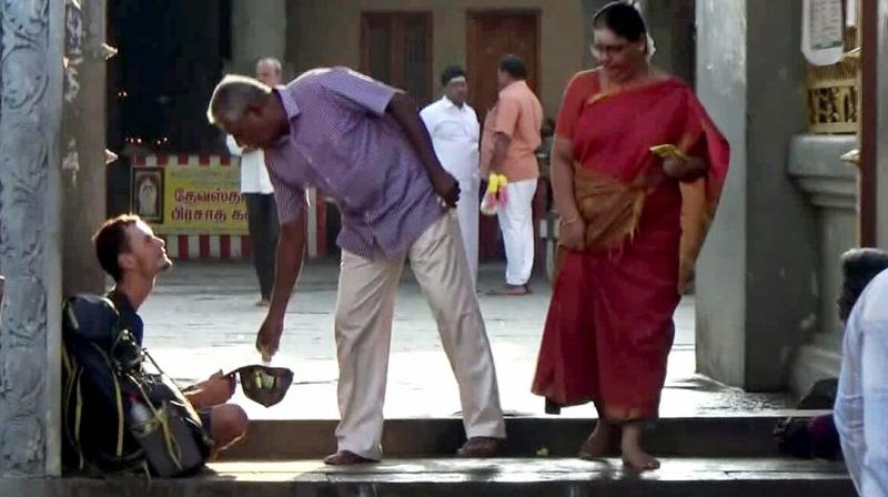 A temple visitor offers money to Evangelin Berngowe at Kumarakottam Murugan temple in Kancheepuram. (Photo: DC) A temple visitor offers money to Evangelin Berngowe at Kumarakottam Murugan temple in Kancheepuram. (Photo: DC)