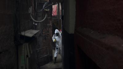 Jorge Alexandre sprays disinfectant in an alleyway to help contain the spread of the new coronavirus, at Santa Marta slum in Rio de Janeiro, Brazil on Friday. (AP)