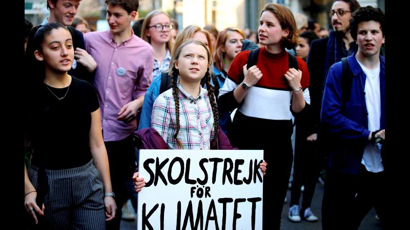 Swedish teenager Greta Thunberg (centre), carrying a sign that reads: "school strike for the climate", leads a march of thousands of French students through Paris on Friday. (Photo:AP) Swedish teenager Greta Thunberg (centre), carrying a sign that reads: "school strike for the climate", leads a march of thousands of French students through Paris on Friday. (Photo:AP)