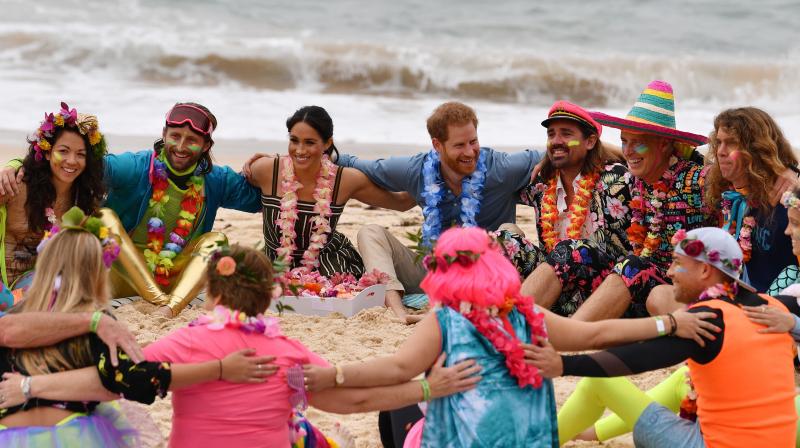 Britain's Prince Harry and his wife Meghan, Duchess of Sussex join a circle during a "Fluro Friday" session run by OneWave, a local surfing community group who raise awareness for mental health and wellbeing, at Sydney's iconic Bondi Beach on October 19, 2018. (Photo: AFP) Britain's Prince Harry and his wife Meghan, Duchess of Sussex join a circle during a "Fluro Friday" session run by OneWave, a local surfing community group who raise awareness for mental health and wellbeing, at Sydney's iconic Bondi Beach on October 19, 2018. (Photo: AFP)