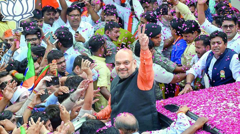 BJP president Amit Shah flashes the victory sign as he arrives at the party headquarters in New Delhi on Thursday. — PTI BJP president Amit Shah flashes the victory sign as he arrives at the party headquarters in New Delhi on Thursday. — PTI