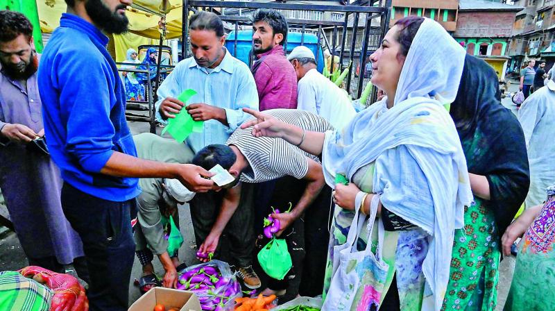 Locals purchase food and vegetables during a lockdown in Srinagar on Saturday. (AFP) Locals purchase food and vegetables during a lockdown in Srinagar on Saturday. (AFP)