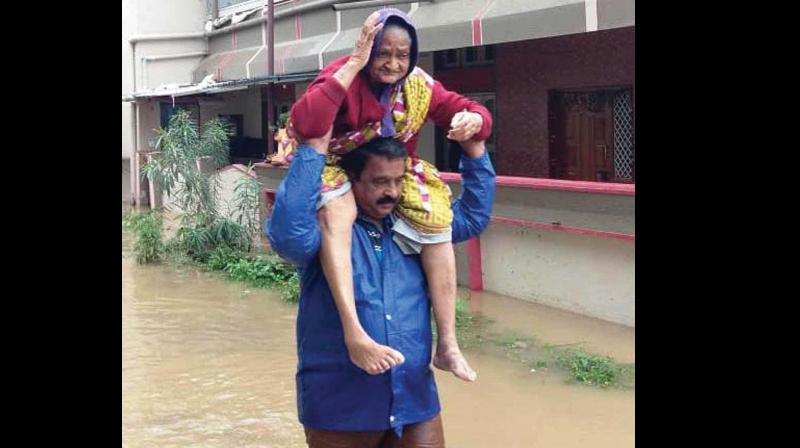 An aged woman from a flood-hit area being carried to a safe place in Shivamogga on Saturday. (KPN) An aged woman from a flood-hit area being carried to a safe place in Shivamogga on Saturday. (KPN)