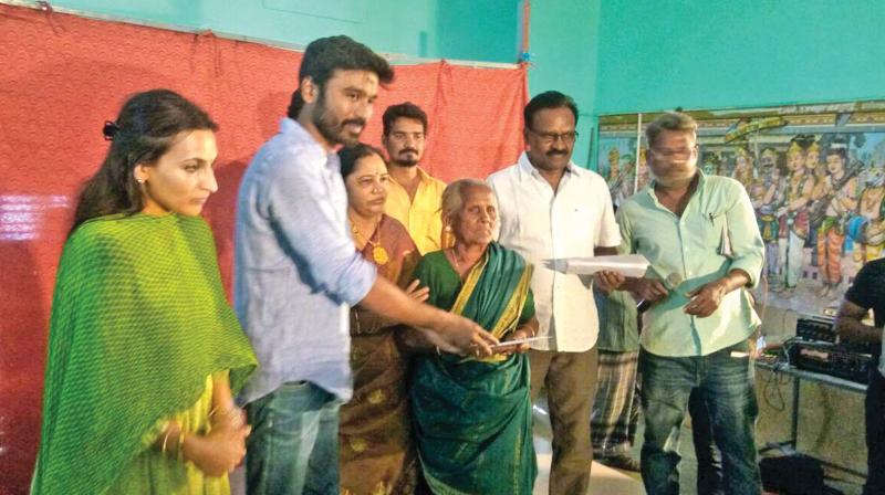 Dhanush distributing money to the farmers Dhanush distributing money to the farmers