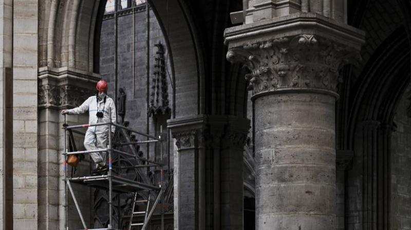 Workers are creating a wooden walkway to gain access to the 250 tons of burnt-out scaffolding that had been installed for the ill-fated restoration of the spire. (Photo: AP) Workers are creating a wooden walkway to gain access to the 250 tons of burnt-out scaffolding that had been installed for the ill-fated restoration of the spire. (Photo: AP)