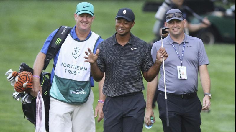 Tiger Woods gestures while talking to his caddie Joe LaCava (L) and an official during a practice round in Paramus, New Jersey, in 2018.