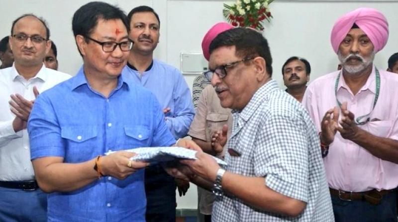 File photo of Sports Minister Kiren Rijiju honouring Ashok Diwan. Twitter Photo