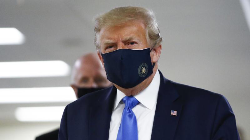 US President Donald Trump wears a mask as he walks down the hallway during his visit to Walter Reed National Military Medical Center in Bethesda. (AP)