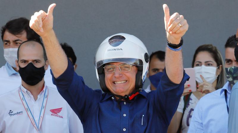 Brazilian President Jair Bolsonaro gestures after going out for a ride and having his motorcycle's engine overhaul after he announced he tested negative for COVID-19 more than two weeks after being diagnosed, in Brasilia. (AFP) Brazilian President Jair Bolsonaro gestures after going out for a ride and having his motorcycle's engine overhaul after he announced he tested negative for COVID-19 more than two weeks after being diagnosed, in Brasilia. (AFP)