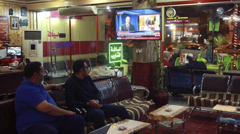 Men at a cafe in Baghdad watch the news on Iraq being removed from the US travel ban. (Photo: AP) Men at a cafe in Baghdad watch the news on Iraq being removed from the US travel ban. (Photo: AP)