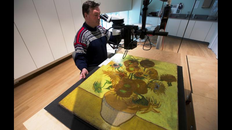 Senior paintings conservator Rene Boitelle works on restoring Vincent van Gogh's world-famous "Sunflowers" painting at the Van Gogh museum in Amsterdam, Netherlands. (Photo: AP) Senior paintings conservator Rene Boitelle works on restoring Vincent van Gogh's world-famous "Sunflowers" painting at the Van Gogh museum in Amsterdam, Netherlands. (Photo: AP)