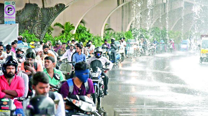 Bikers are forced to take shelter from the heavy rains under a flyover (Photo: S. Surender Reddy) Bikers are forced to take shelter from the heavy rains under a flyover (Photo: S. Surender Reddy)