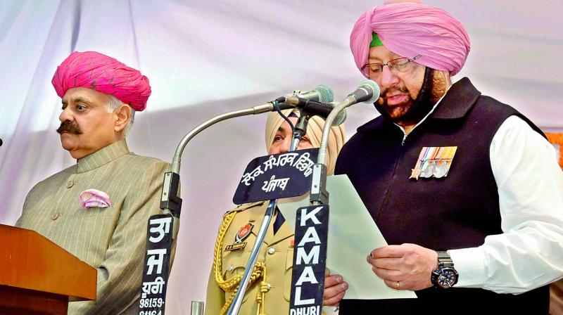 Punjab Governor V.P. Singh Badnore administering oath to the new Punjab Chief Minister Amarinder Singh at the Raj Bhavan in Chandigarh on Thursday. Also sworn into the Cabinet was former cricketer Navjot Singh Sidhu (not in picture), who, as per TV reports, was seen touching Amarinder’s feet after the event. (Photo: PTI) Punjab Governor V.P. Singh Badnore administering oath to the new Punjab Chief Minister Amarinder Singh at the Raj Bhavan in Chandigarh on Thursday. Also sworn into the Cabinet was former cricketer Navjot Singh Sidhu (not in picture), who, as per TV reports, was seen touching Amarinder’s feet after the event. (Photo: PTI)