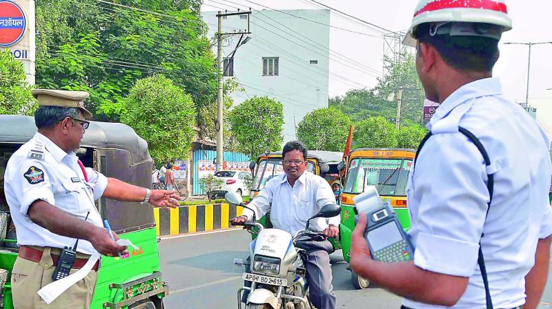 Traffic police stopped two-wheelers, who were not wearing the helmet on Bandar road in Vijayawada on Saturday. (Photo: DC) Traffic police stopped two-wheelers, who were not wearing the helmet on Bandar road in Vijayawada on Saturday. (Photo: DC)