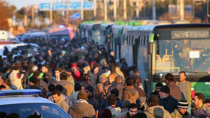 Residents gathered near green government buses as they hold their belongings for evacuation from eastern Aleppo, Syria. (Photo: File) Residents gathered near green government buses as they hold their belongings for evacuation from eastern Aleppo, Syria. (Photo: File)