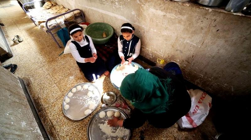 Um Yusuf, a widow of an Islamic State group militant and her daughters make bread to sell in Mosul, Iraq. (Photo: AP) Um Yusuf, a widow of an Islamic State group militant and her daughters make bread to sell in Mosul, Iraq. (Photo: AP)