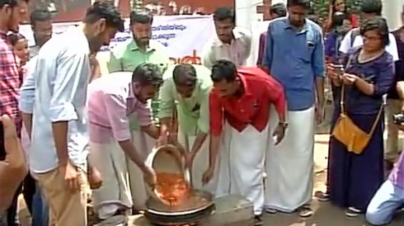 SFI protests on cattle slaughter ban by eating beef outside University College in Thiruvananthapuram. (Photo: Twitter | ANI) SFI protests on cattle slaughter ban by eating beef outside University College in Thiruvananthapuram. (Photo: Twitter | ANI)