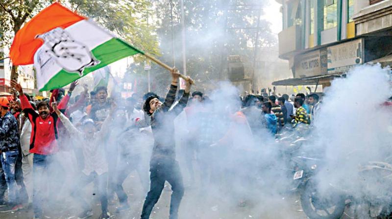 A jubilant Congress worker waves the party flag in Jabalpur on Tuesday. (Photo: PTI) A jubilant Congress worker waves the party flag in Jabalpur on Tuesday. (Photo: PTI)