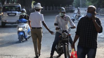 An Indian policeman questions a commuter at a checkpoint during lockdown. (AP)
