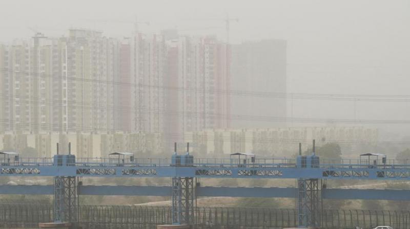Vehicles cross a barrage on Hindon river as dust covers the skyline in Ghaziabad. (Photo: AFP) Vehicles cross a barrage on Hindon river as dust covers the skyline in Ghaziabad. (Photo: AFP)
