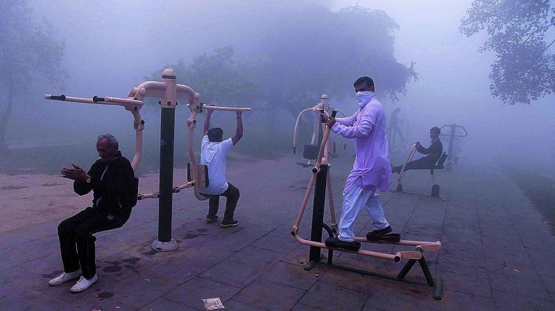 Braving the pollution, people seen doing exercise at a public park in New Delhi on Wednesday morning. (Photo: PTI) Braving the pollution, people seen doing exercise at a public park in New Delhi on Wednesday morning. (Photo: PTI)