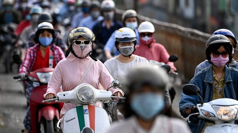 In this file photo taken, morning commuters wearing face masks, amidst concerns about the spread of the Covid-19 coronavirus, ride past in Hanoi. (Photo: AFP)