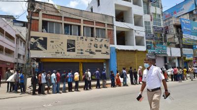 People stand in queue receive free food during COVID-induced lockdown in Bengaluru. (Photo: PTI)