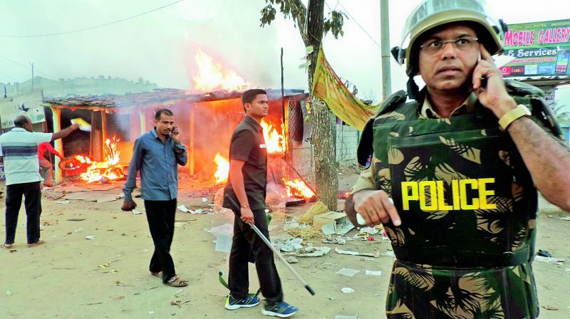 Superintendent of police P. Srinivas speaks on a cellphone at Husnabad where clashes broke out between Adivasi and Lambada groups. (Photo: DC) Superintendent of police P. Srinivas speaks on a cellphone at Husnabad where clashes broke out between Adivasi and Lambada groups. (Photo: DC)